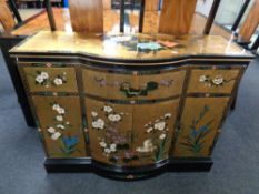 A gold lacquered Japanese style bow fronted sideboard fitted drawers above