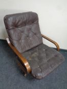 A 20th century swivel armchair upholstered in brown buttoned leather