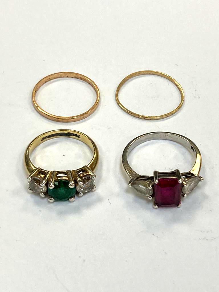 A yellow gold band ring (0.9g), together with a further band ring and two dress rings.