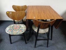 A 20th century G Plan teak and ebonised dining table and three chairs