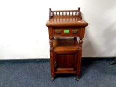 A late 19th century oak pot cupboard with gallery rail back,