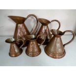 A vintage set of five graduated Victorian copper measuring jugs.