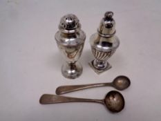 Two silver pepper pots together with two further silver spoons
