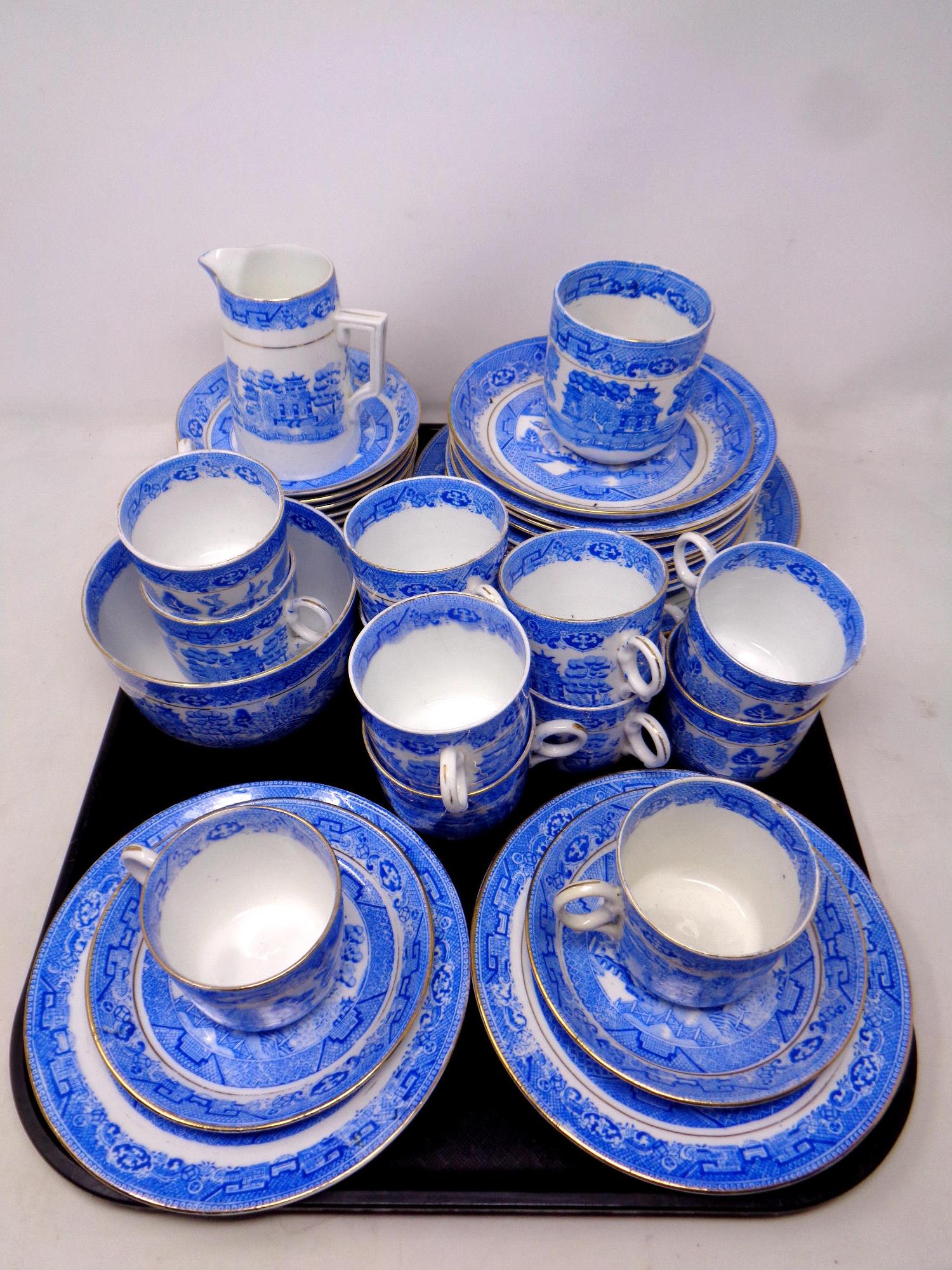 A tray containing forty pieces of antique Staffordshire willow pattern tea china