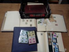 A crate of stamp albums and folders containing early twentieth century and later stamps of the