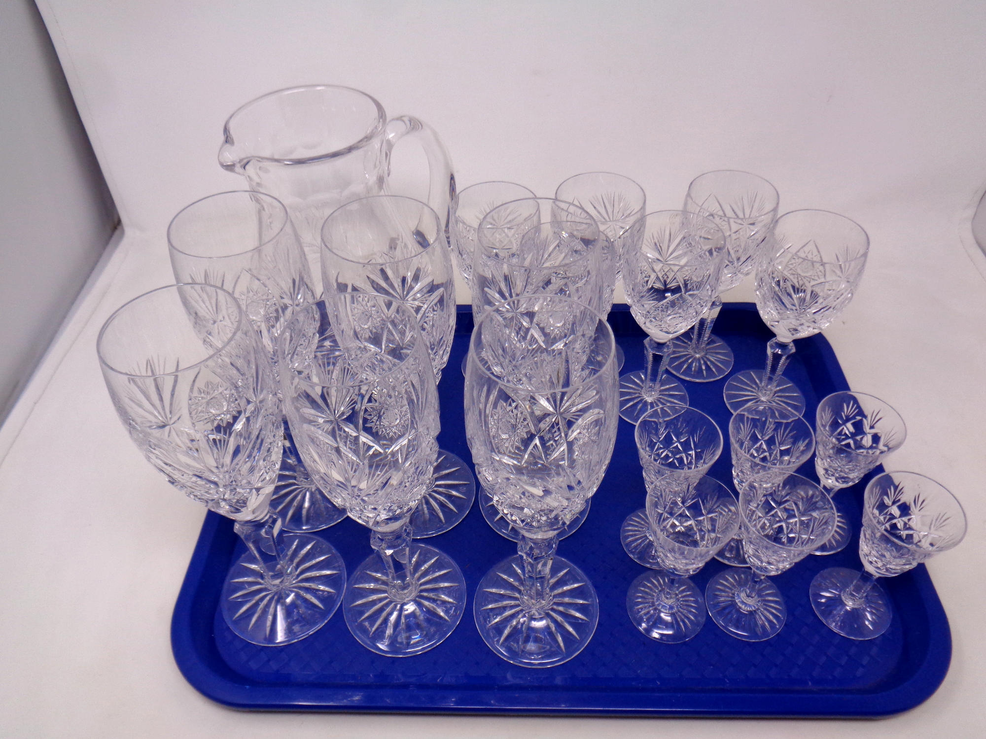 A tray of three sets of six Stuart Crystal glasses together with a cut glass lead crystal water jug