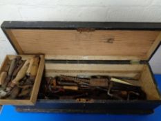 A vintage pine joiner's tool box containing assorted tools to include brace, chisels, spanners,