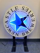 A vintage metal double-sided and illuminated Newcastle Breweries adverting sign mounted on bracket,