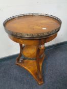 A reproduction yew wood occasional table with brass gallery top