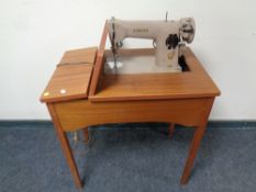 A Singer electric sewing machine in teak table,