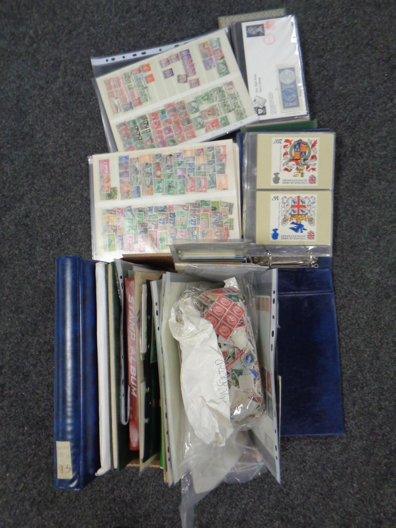 A box of albums and folders of stamps, postcards,