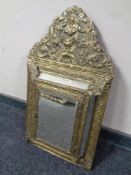 An ornate brass cushion framed mirror wall cabinet