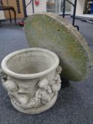 A concrete garden cherub planter together with a stepping stone