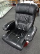 A black leather swivel reclining armchair on circular base