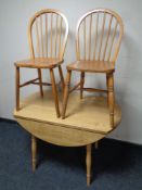 A drop leaf kitchen table together with a pair of stick back dining chairs