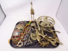 A tray of assorted metal ware to include graduated keys, metal face masks, trivet,