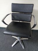 A chrome framed gas lift barber's chair
