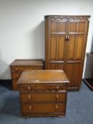 A three piece oak linen fold bedroom suite : double wardrobe and pair of three drawer chests