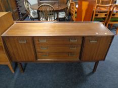 A 20th century teak sideboard fitted with three central drawers