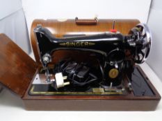 A vintage Singer electric sewing machine in case, in case, with the extension panel.