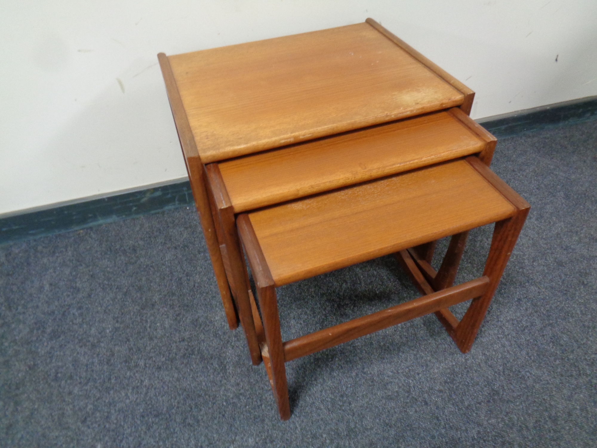 A 20th century nest of three teak tables