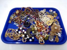 A tray of assorted costume jewellery, pendants on chains, brooches,