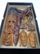 A box of carved African tourist pieces and wall masks
