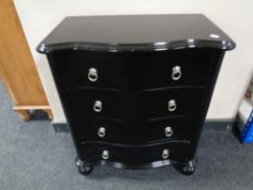 A black lacquered serpentine fronted five drawer chest