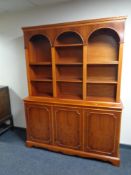 A yew wood bookcase fitted with cupboards beneath