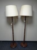 A pair of beech standard lamps with shades