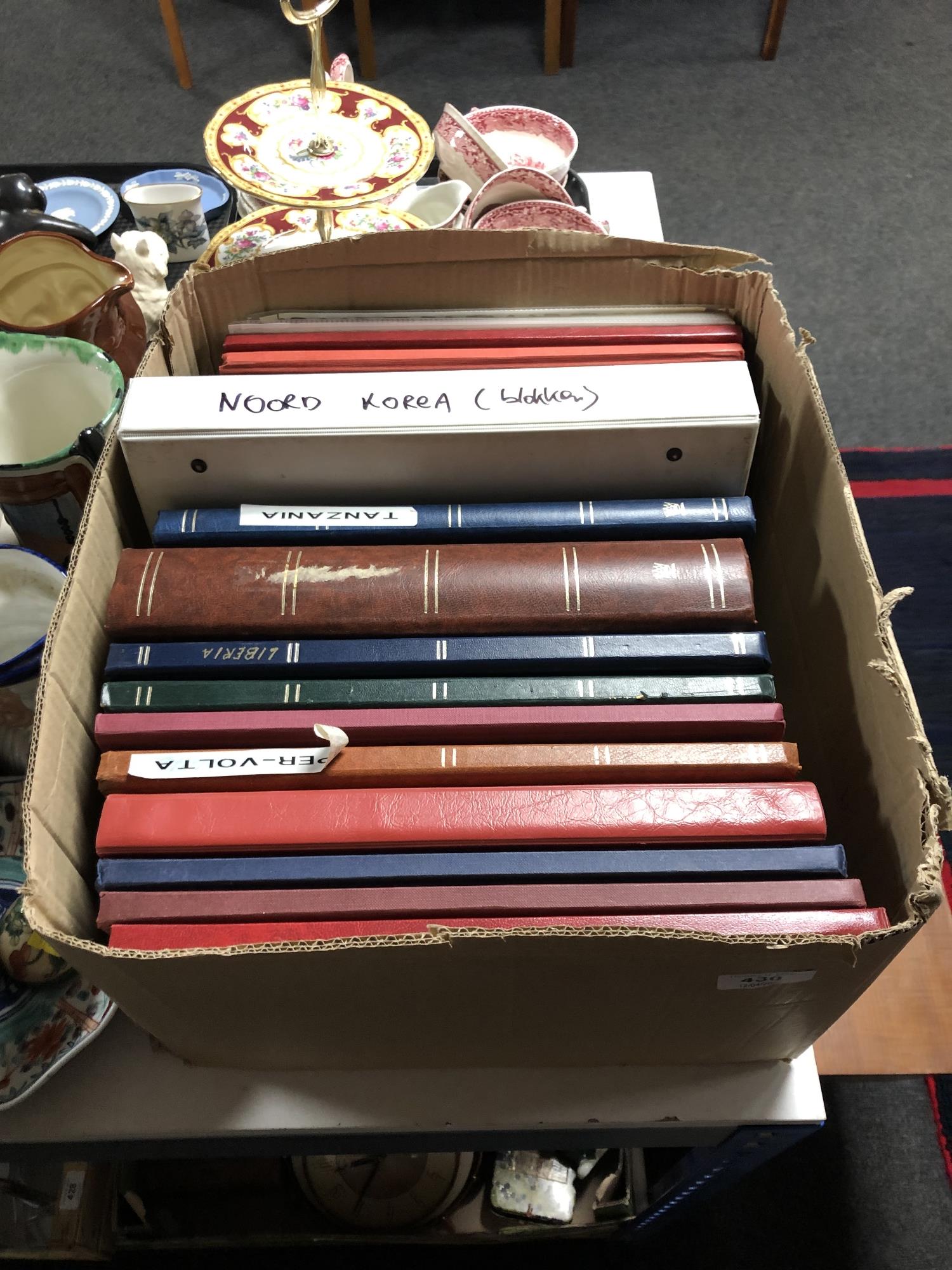 A box containing fifteen albums and folders of world stamps