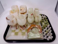 A tray of marble chess set and pieces (as found), two sets of marble goblets,