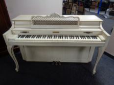 A Baldwin American made overstrung piano in cream and gilt case