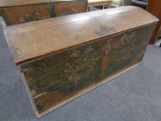A 19th century oak dome topped shipping trunk with hand painted decoration and key