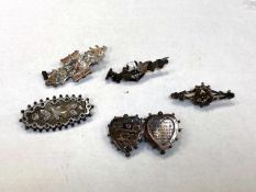 A group of antique silver brooches.