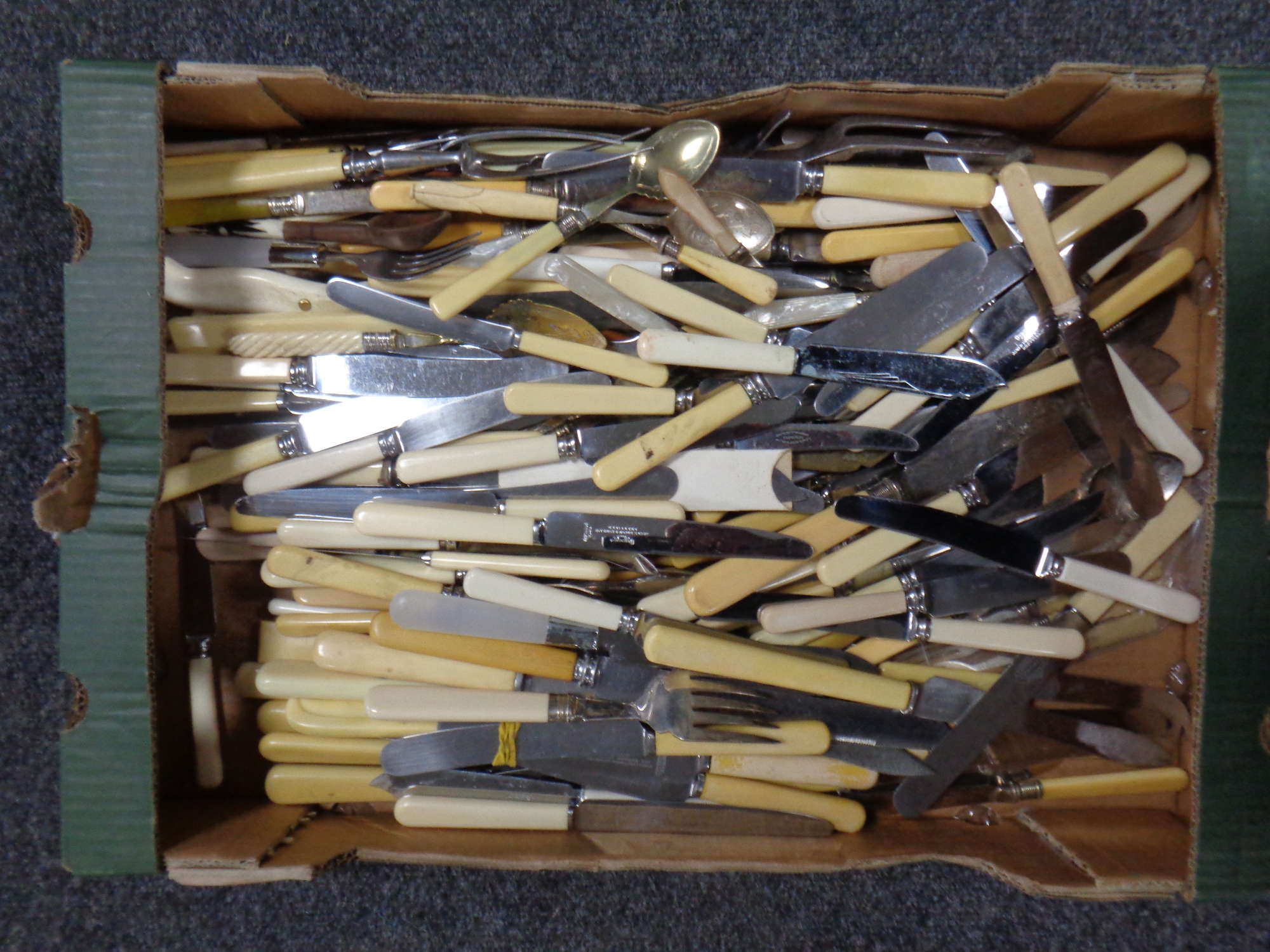 A box of stainless steel and plated cutlery