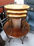 An early 20th century circular beech occasional table together with a further nest of three tables