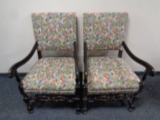 A pair of carved oak early 20th century scroll arm armchairs in a tapestry fabric