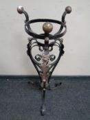 An antique wrought iron and copper oil lamp stand