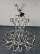 An impressive contemporary metal and glass nine arm thirty-six light chandelier