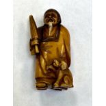 A Japanese carving depicting a Gentleman holding a parasol, height 50 mm.