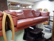 A 20th century wood framed and red leather three seater settee and matching two seater settee
