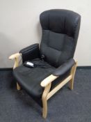 A wood framed black leather electric adjustable armchair (continental wiring)