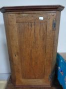 An Edwardian oak wall mounted corner cabinet with panel door, height 59.