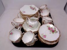 A tray of forty pieces of antique white and gilt rose pattern tea china