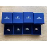 Four Swarovski crystal dress rings in retail boxes.