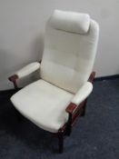 A stained beech framed armchair upholstered in a cream fabric