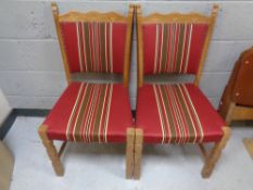 A set of four Scandinavian oak dining chairs upholstered in red striped fabric