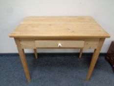 An early 20th century stripped pine side table fitted a drawer