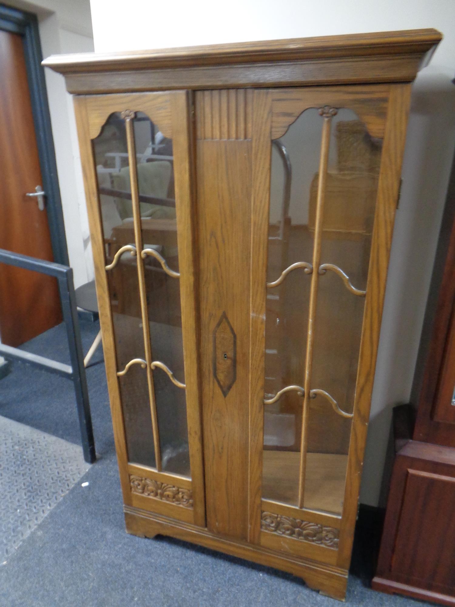 An early 20th century oak double door glazed bookcase